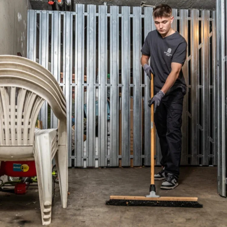 Kellerentrümpelung Köln - Mitarbeiter fegt die letzten Reste weg